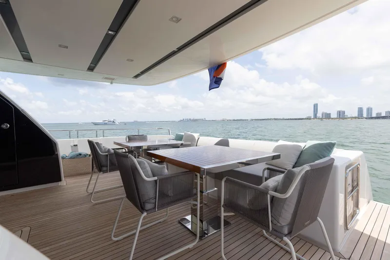 Sasa Yacht Photos Pics Outdoor deck of 2022 Sanlorenzo SL86 yacht with seating, overlooking ocean and city skyline.