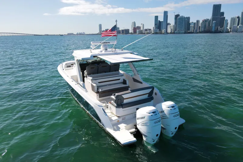  Yacht Photos Pics 2022 Tiara Yachts 34 LS cruising near city skyline, featuring twin Mercury 400 engines.
