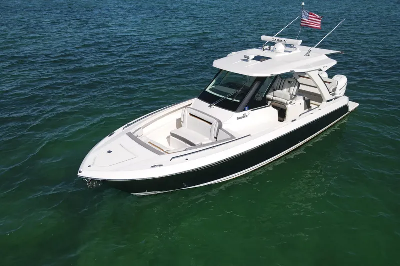  Yacht Photos Pics 2022 Tiara Yachts 34 LS boat on clear blue water, featuring sleek design and American flag.