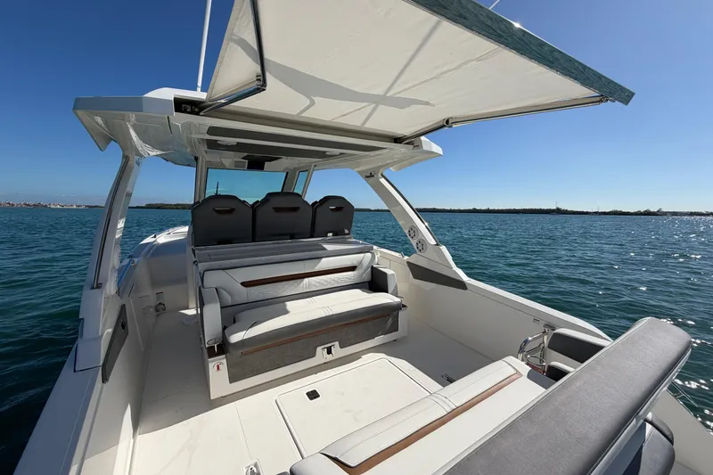  Yacht Photos Pics 2022 Tiara Yachts 34 LS boat with spacious seating and sunshade on open water.