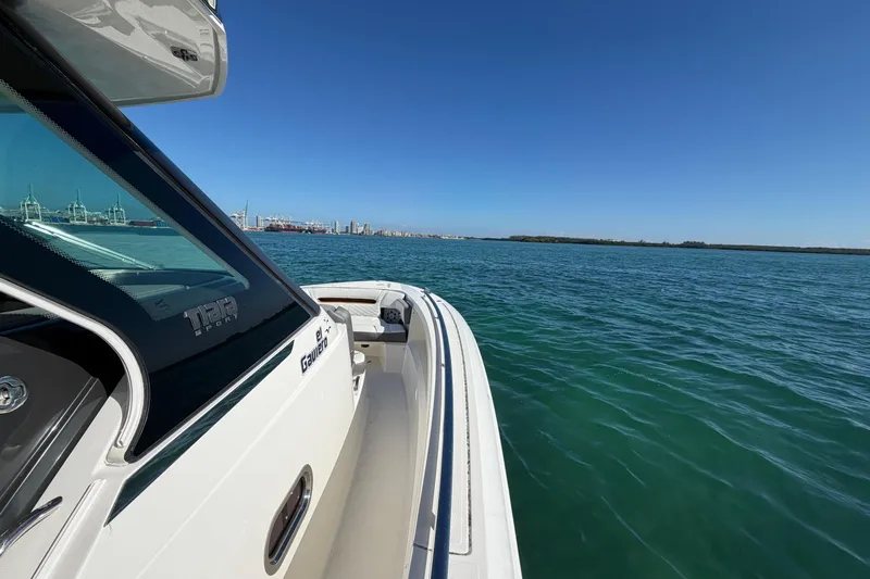  Yacht Photos Pics 2022 Tiara Yachts 34 LS cruising on open water under clear blue skies.