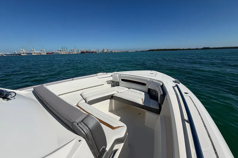  Yacht Photos Pics 2022 Tiara Yachts 34 LS on open water with cityscape and port in background.