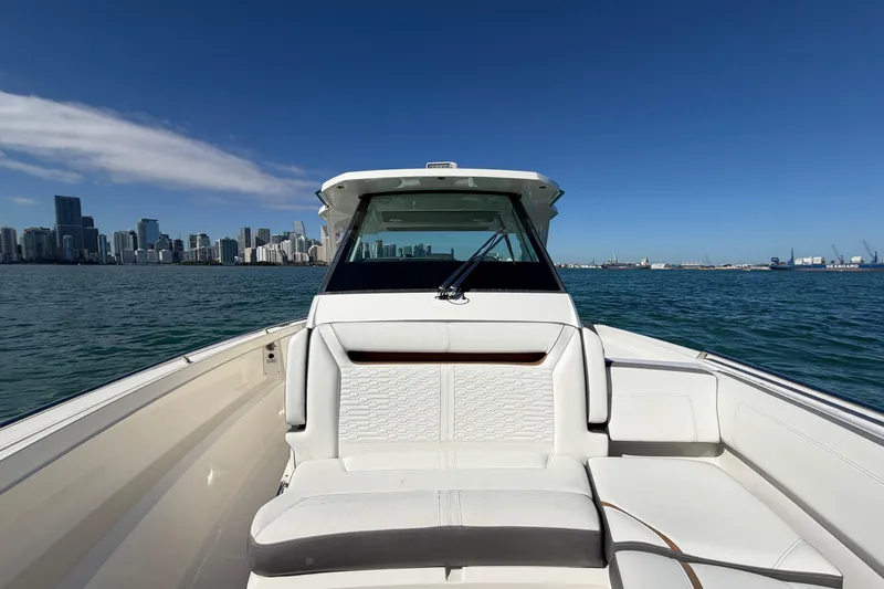  Yacht Photos Pics 2022 Tiara Yachts 34 LS on water with city skyline in background.