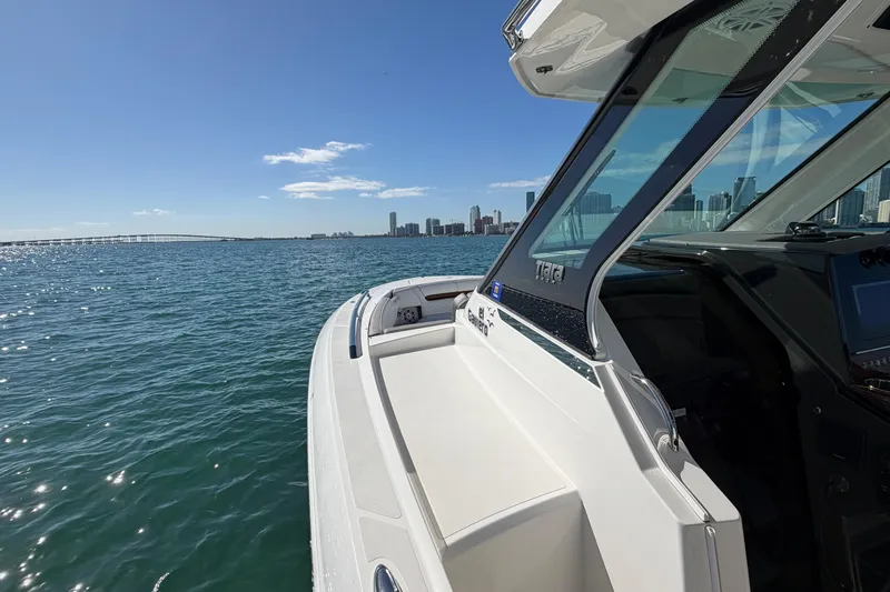  Yacht Photos Pics 2022 Tiara Yachts 34 LS cruising on a sunny day with city skyline in background.