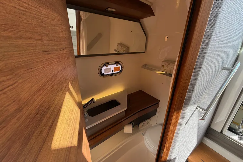  Yacht Photos Pics 2022 Tiara Yachts 34 LS bathroom interior with sink, mirror, and wooden accents.
