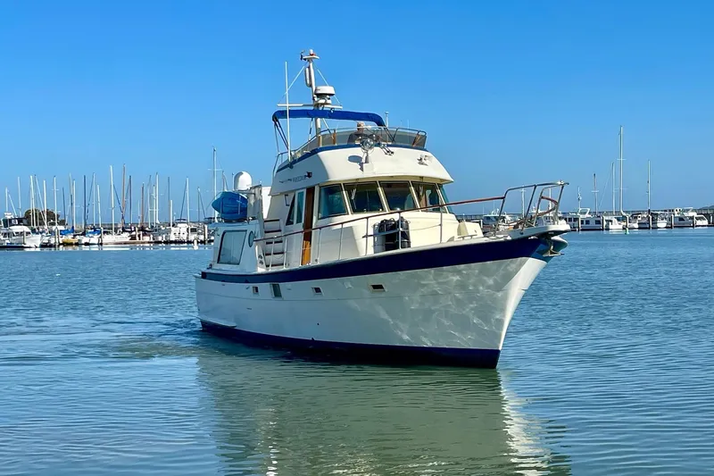Freedom Yacht Photos Pics 1976 Hatteras 48 Long Range Cruiser in marina, clear blue sky, calm water.