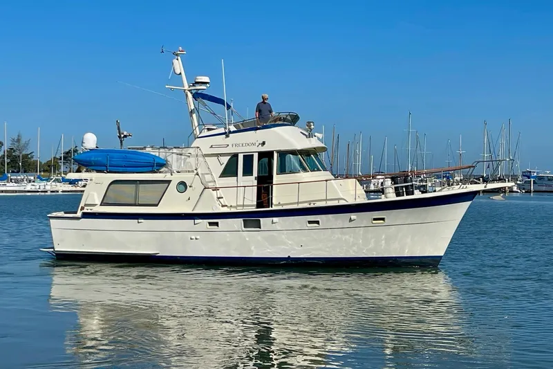 Freedom Yacht Photos Pics 1976 Hatteras 48 Long Range Cruiser yacht docked in a marina, clear blue sky.
