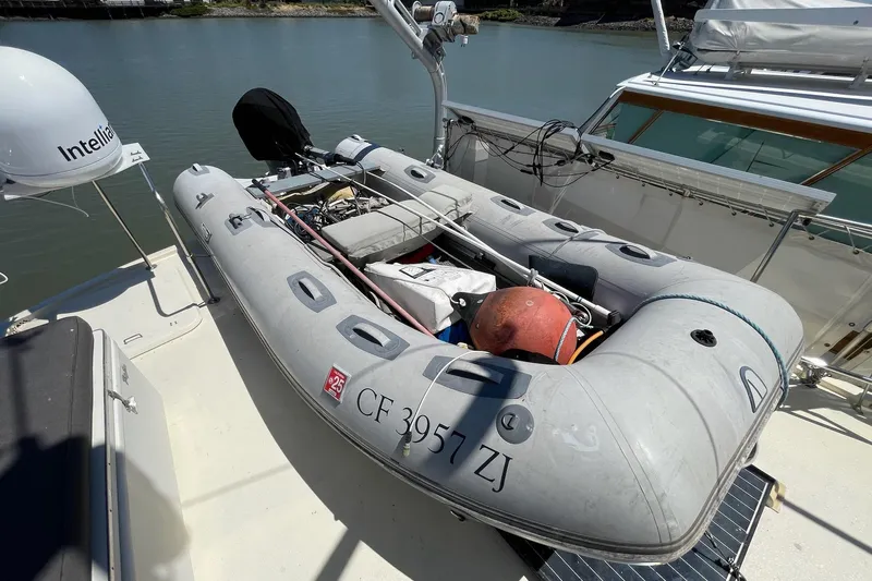 Freedom Yacht Photos Pics Inflatable dinghy on 1976 Hatteras 48 Long Range Cruiser, docked by the water.