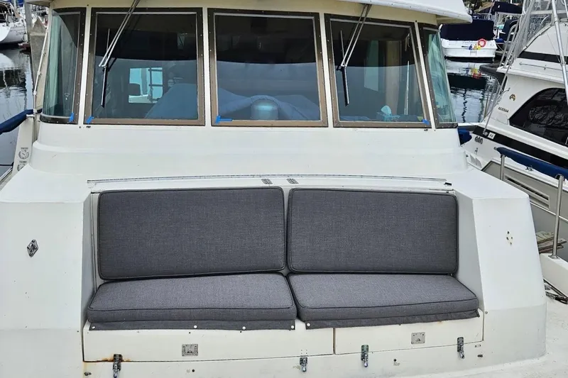 Freedom Yacht Photos Pics 1976 Hatteras 48 Long Range Cruiser with gray cushioned seating at the stern.