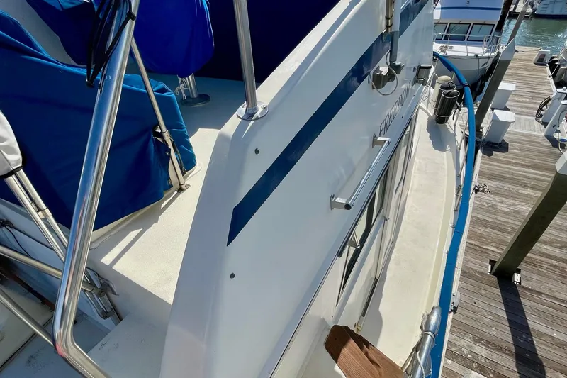 Freedom Yacht Photos Pics 1976 Hatteras 48 Long Range Cruiser docked, featuring blue accents and stainless steel railings.