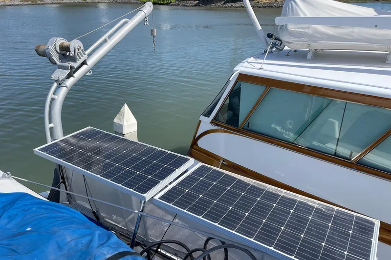 Freedom Yacht Photos Pics 1976 Hatteras 48 Long Range Cruiser with solar panels docked by the water.