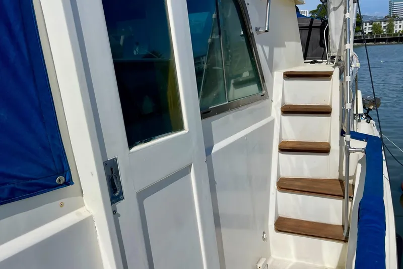 Freedom Yacht Photos Pics 1976 Hatteras 48 Long Range Cruiser with wooden steps and blue canvas cover.