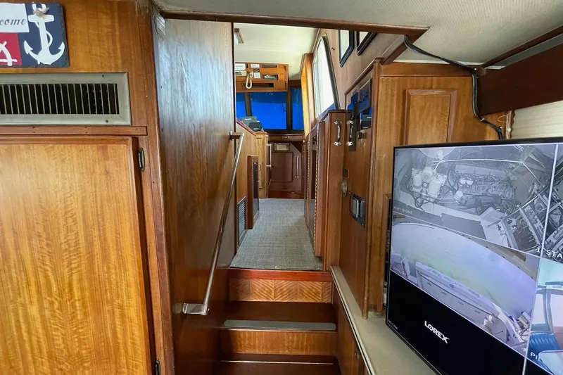 Freedom Yacht Photos Pics Interior of 1976 Hatteras 48 Long Range Cruiser with wood paneling and security monitor.