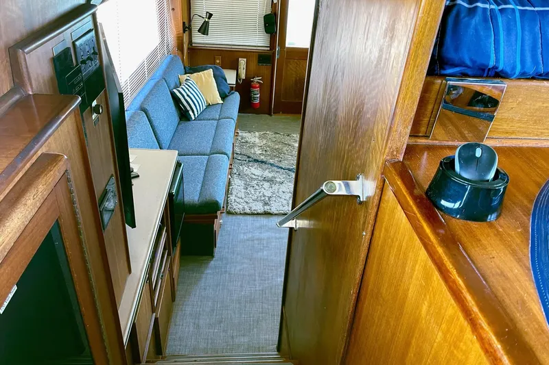 Freedom Yacht Photos Pics Interior of 1976 Hatteras 48 Long Range Cruiser with blue sofa and wooden accents.