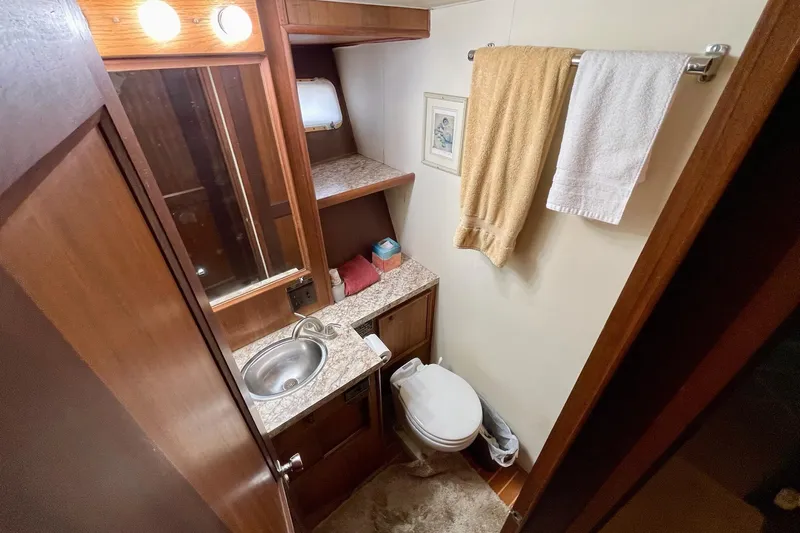 Freedom Yacht Photos Pics Bathroom interior of 1976 Hatteras 48 Long Range Cruiser with sink, toilet, and towels.