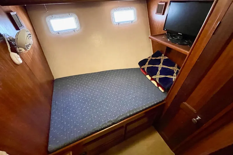 Freedom Yacht Photos Pics 1976 Hatteras 48 Long Range Cruiser cabin with bed, portholes, and TV.