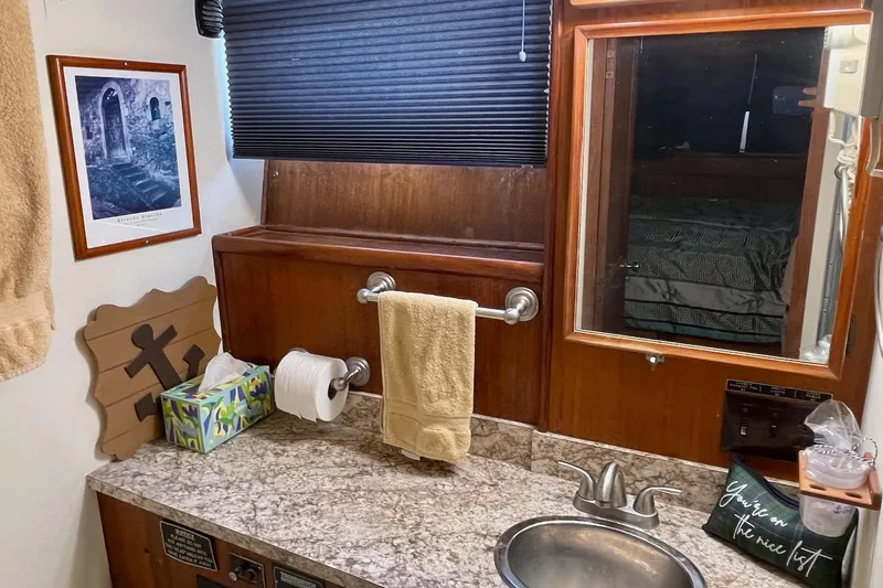 Freedom Yacht Photos Pics Bathroom interior of 1976 Hatteras 48 Long Range Cruiser with granite countertop and wooden accents.