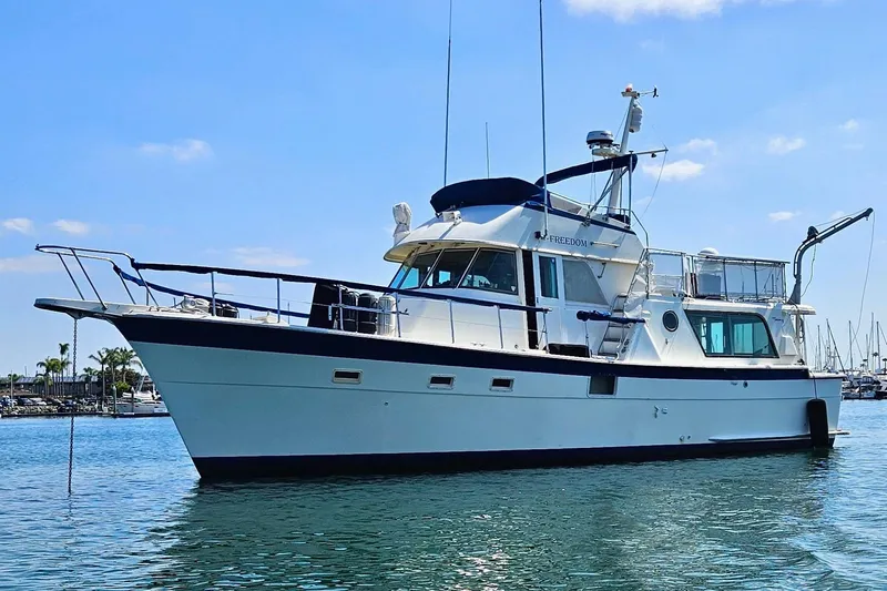 Freedom Yacht Photos Pics 1976 Hatteras 48 Long Range Cruiser yacht on calm water under blue sky.