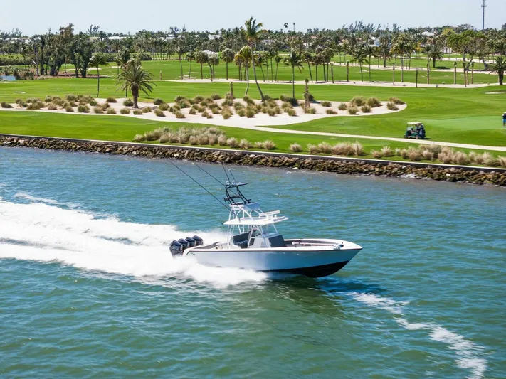  Yacht Photos Pics 2021 SeaVee 390Z boat cruising on a waterway near a golf course.