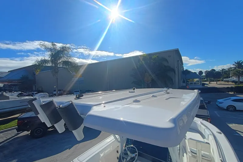 250-118 Yacht Photos Pics 2026 Robalo R250 Center Console boat under bright sun, parked near palm trees.