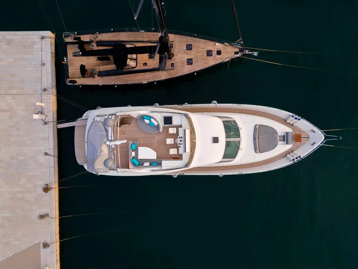 Cool Running Yacht Photos Pics Aerial view of 2003 Mochi Craft 22.5 Axis yacht docked beside a wooden boat.