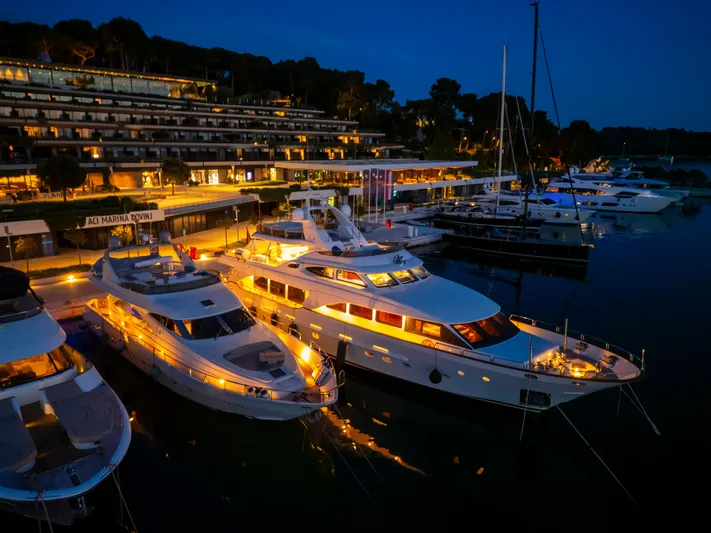 Cool Running Yacht Photos Pics Luxurious 2003 Mochi Craft 22.5 Axis yacht docked at night, illuminated in marina.