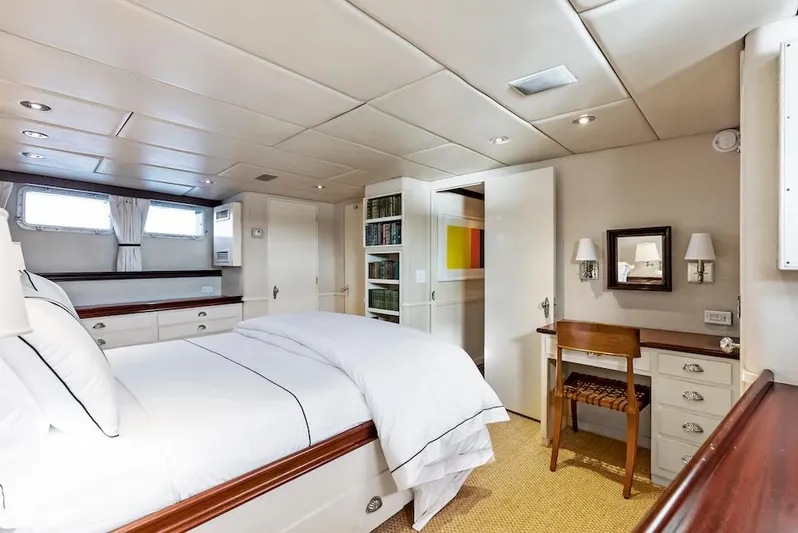 Chanticleer Yacht Photos Pics Luxurious yacht bedroom with elegant decor, featuring a cozy bed and a small desk.
