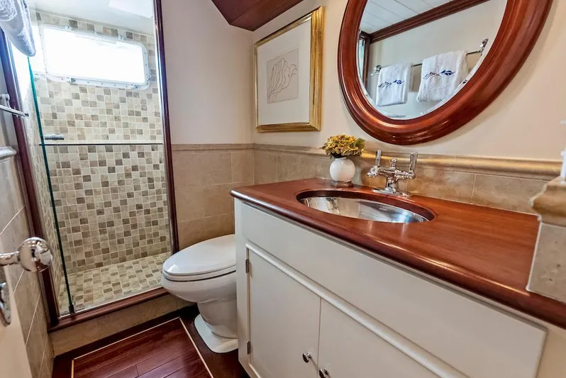 Chanticleer Yacht Photos Pics Luxurious yacht bathroom with wood accents, round mirror, and tiled shower, 1973 Burger 310C.