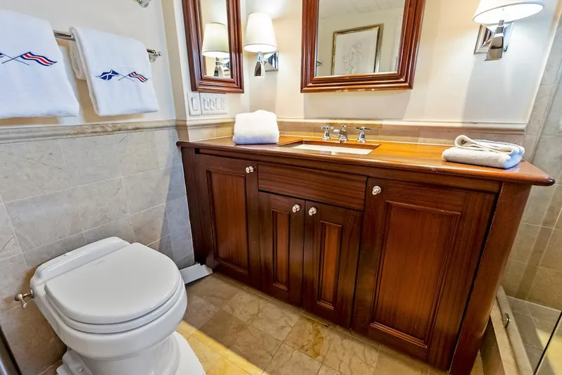 Chanticleer Yacht Photos Pics Luxurious yacht bathroom with wooden vanity, elegant fixtures, and plush towels.