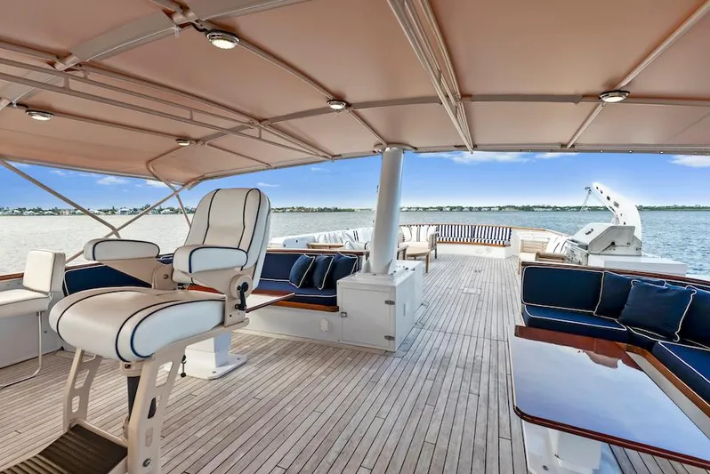 Chanticleer Yacht Photos Pics Luxurious 1973 Burger 310C yacht deck with seating and helm, overlooking serene waters.