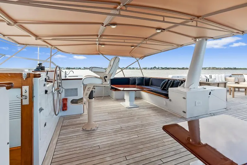 Chanticleer Yacht Photos Pics 1973 Burger 310C yacht deck with seating, steering wheel, and canopy under a clear sky.