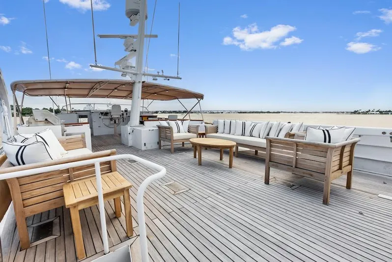 Chanticleer Yacht Photos Pics Spacious deck of a 1973 Burger 310C yacht with wooden furniture and ocean view.