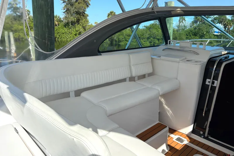 Kinja Yacht Photos Pics Luxurious white seating area on a 2002 Pursuit 3800 Express yacht, surrounded by nature.