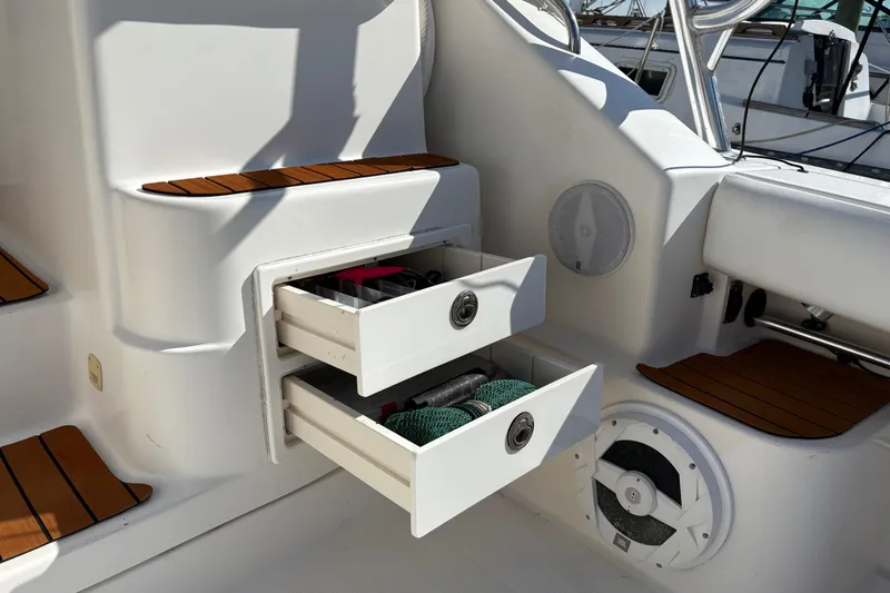 Kinja Yacht Photos Pics 2002 Pursuit 3800 Express boat interior with open storage drawers and wooden accents.
