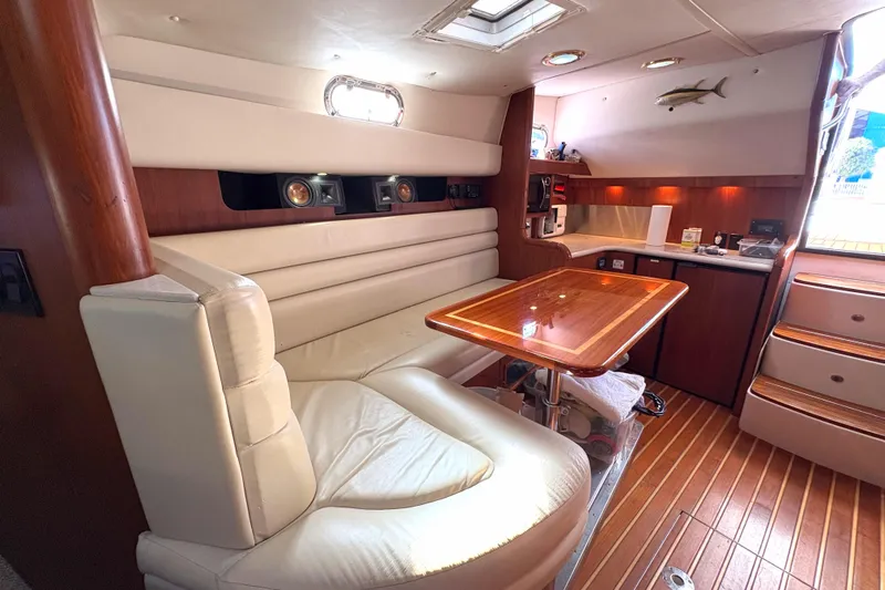 Kinja Yacht Photos Pics Luxurious interior of a 2002 Pursuit 3800 Express yacht with elegant seating and wooden table.
