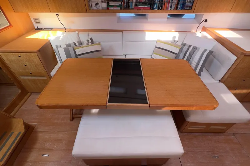  Yacht Photos Pics Interior of 2012 Grand Soleil 50 yacht with wooden table and cushioned seating.