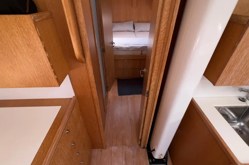  Yacht Photos Pics Interior of 2012 Grand Soleil 50 yacht, featuring wood cabinetry and a cozy bedroom.