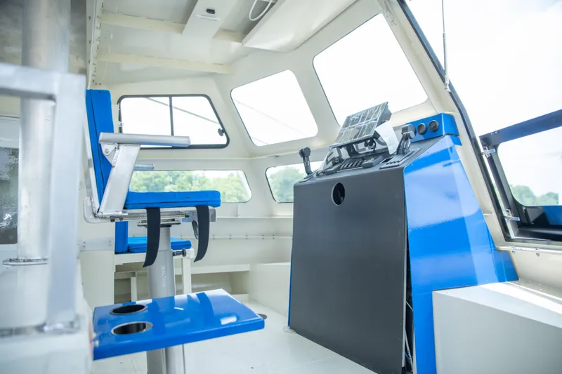Penelope Yacht Photos Pics Interior of 2023 Smoky Mountain asymmetrical foil-assisted catamaran, featuring blue seating and control panel.