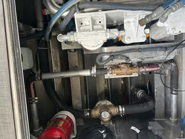 Penelope Yacht Photos Pics Engine compartment of 2023 Smoky Mountain asymmetrical foil-assisted catamaran, featuring pipes and fire extinguisher.