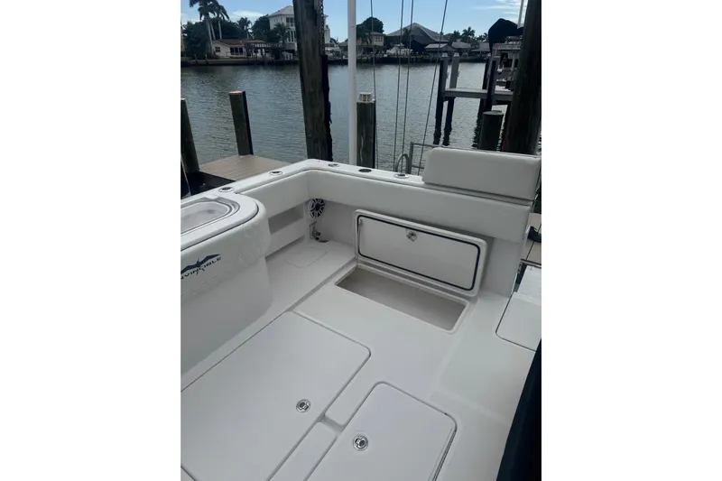  Yacht Photos Pics 2024 Invincible 39 Open Fisherman boat interior at dockside, showcasing storage and seating.