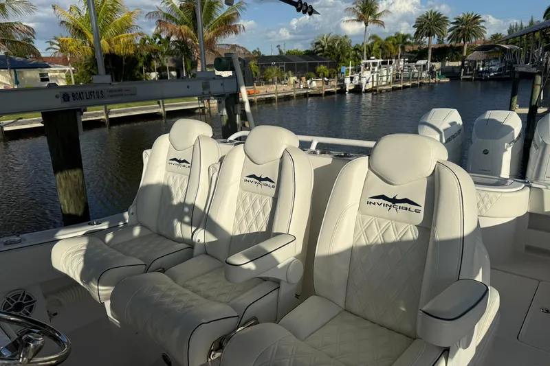  Yacht Photos Pics 2024 Invincible 39 Open Fisherman boat with luxurious white seating and scenic waterfront view.