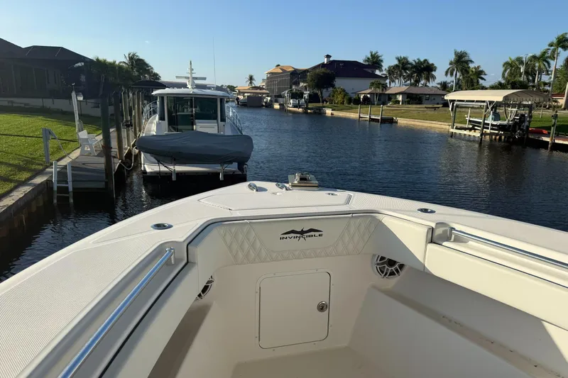  Yacht Photos Pics 2024 Invincible 39 Open Fisherman boat docked in a scenic canal setting.