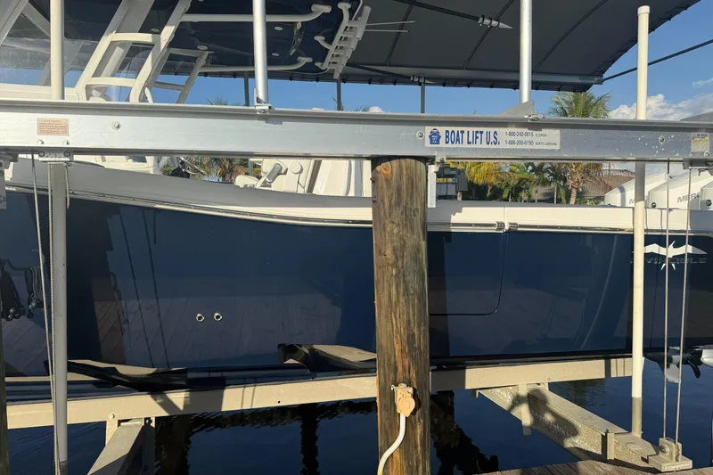  Yacht Photos Pics 2024 Invincible 39 Open Fisherman on boat lift, side view, sunny day.