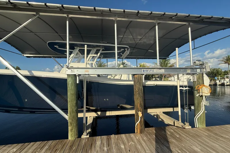  Yacht Photos Pics 2024 Invincible 39 Open Fisherman boat on lift, docked under canopy.
