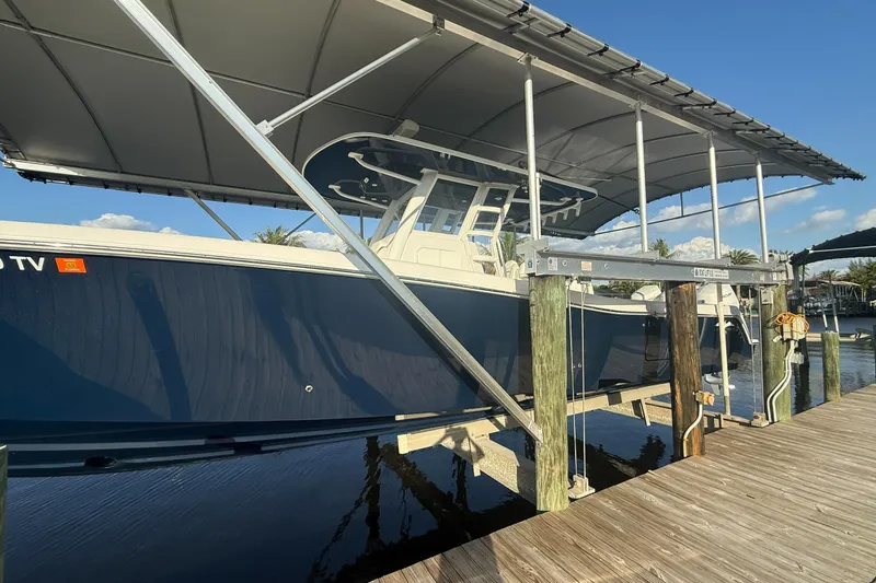 Yacht Photos Pics 2024 Invincible 39 Open Fisherman boat docked under a canopy.