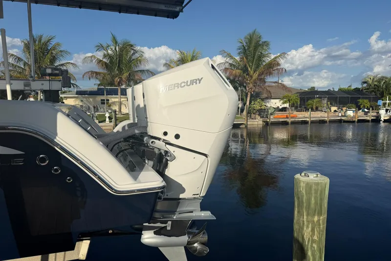  Yacht Photos Pics 2024 Invincible 39 Open Fisherman with Mercury engine docked by palm trees.