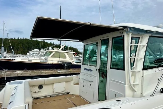  Yacht Photos Pics 2021 Boston Whaler 345 Conquest Pilothouse docked, featuring spacious deck and pilothouse.