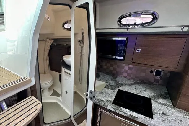  Yacht Photos Pics Interior of 2021 Boston Whaler 345 Conquest Pilothouse with kitchenette and compact bathroom.