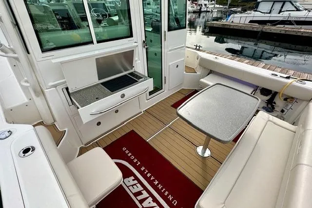  Yacht Photos Pics 2021 Boston Whaler 345 Conquest Pilothouse interior with seating, table, and grill.