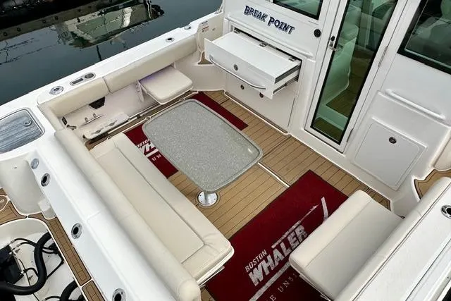  Yacht Photos Pics 2021 Boston Whaler 345 Conquest Pilothouse interior with seating and table.